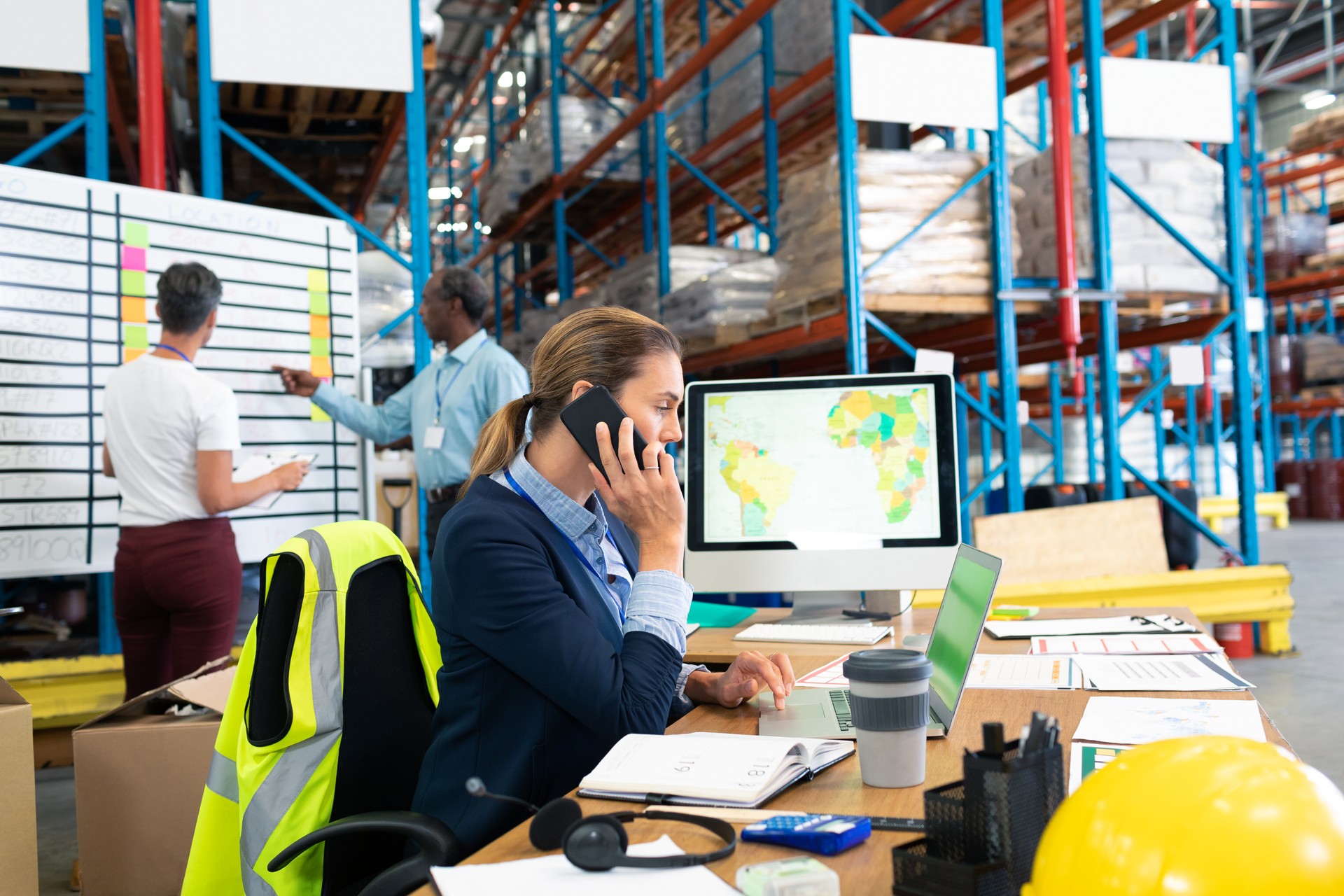 Female manager talking on mobile phone at desk