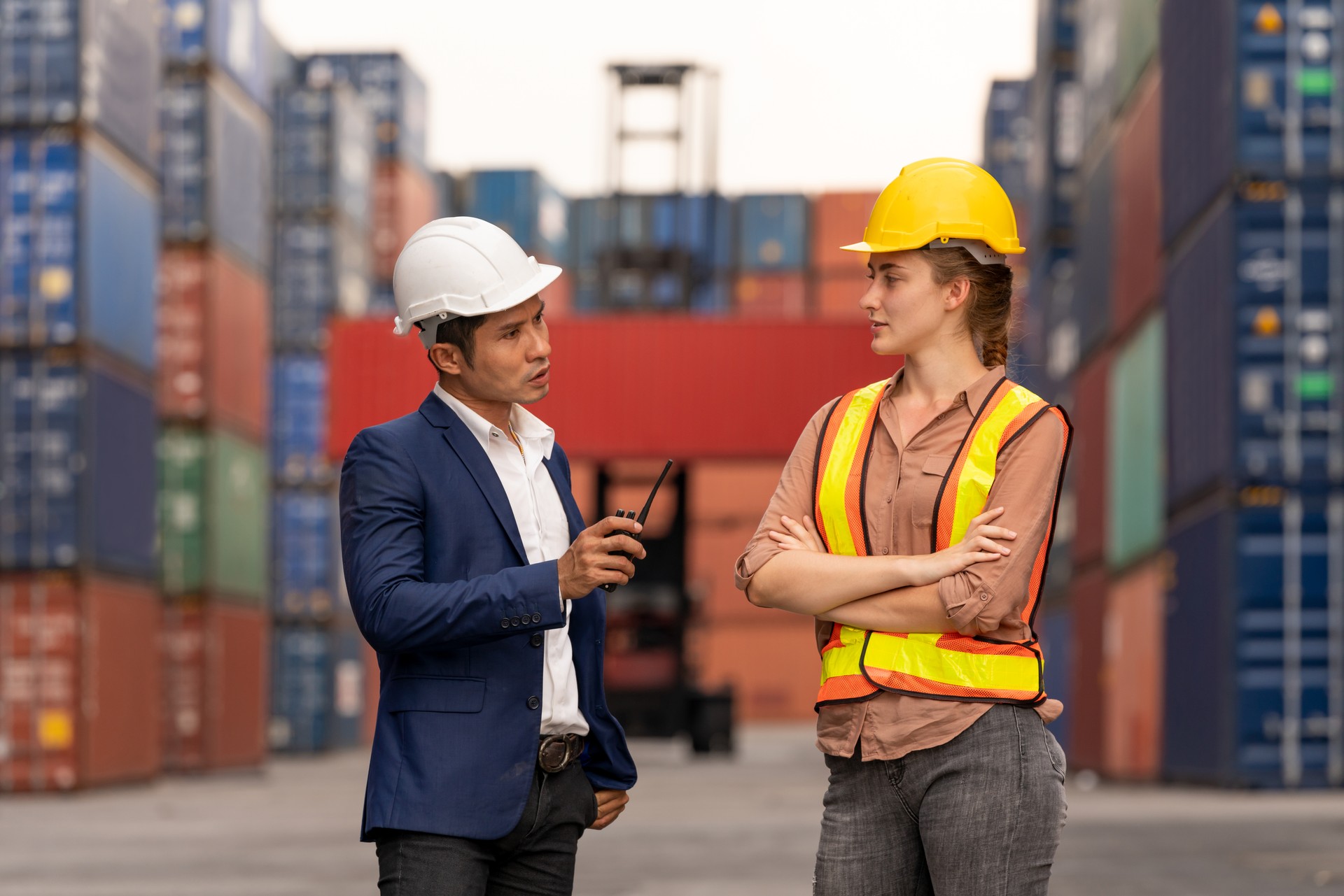 Technician consult with worker about transport cargo container in shipping yard